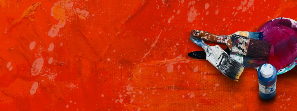 Roter strukturierter Hintergrund mit einem Schälchen dunkelroter Farbe und daneben liegenden Pinseln.
